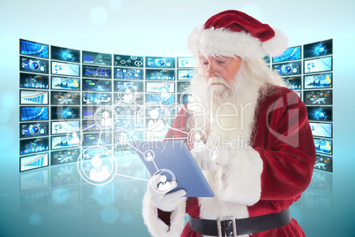 Composite image of santa uses a tablet pc