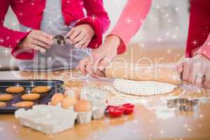 Composite image of festive mother and daughter making christmas