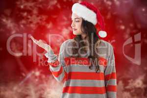 Composite image of festive brunette holding hand out