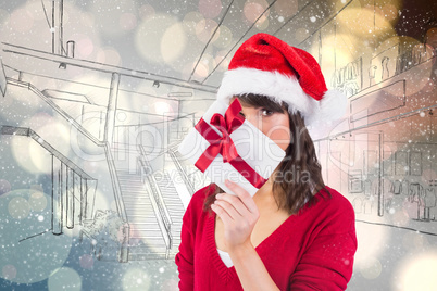 Composite image of festive woman looking at camera holding a gif