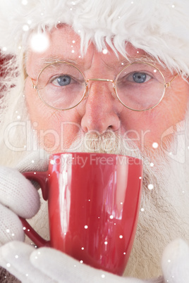 Composite image of santa drinks from a red cup