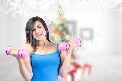 Composite image of smiling fit brunette holding dumbbells