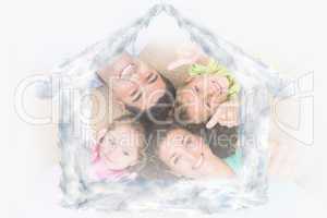Composite image of smiling family lying on the rug in a circle s