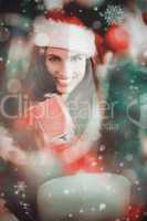 Composite image of festive brunette pressing gift at christmas