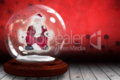 Santa doing yoga in snow globe