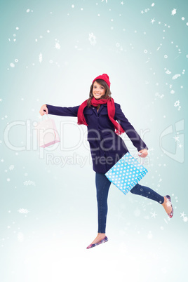 Composite image of festive brunette holding shopping bags