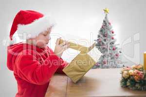 Composite image of cute boy opening gift