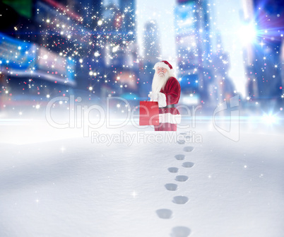 Composite image of santa carrying gifts in the snow