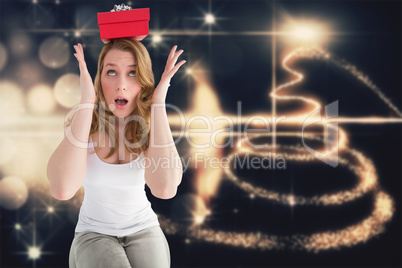 Composite image of woman balancing christmas gift on her head