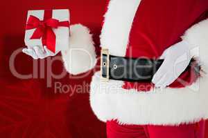 Composite image of mid section of santa holding gift