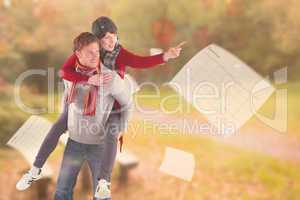 Composite image of man giving girlfriend piggy back