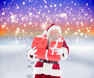 Composite image of santa carrying gifts in the snow