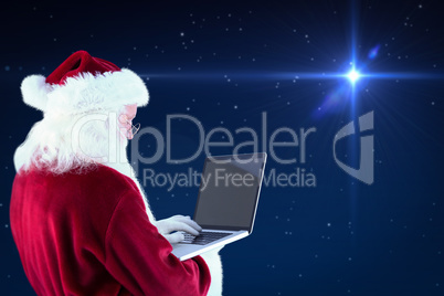 Composite image of santa claus uses a laptop