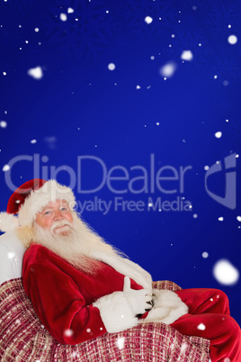 Composite image of santa holding his belly on the armchair
