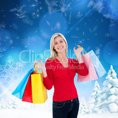 Composite image of happy blonde holding shopping bags