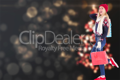 Composite image of festive blonde holding shopping bags