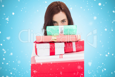 Composite image of portrait of a brunette holding pile of gifts