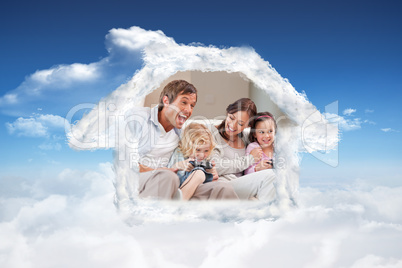 Composite image of laughing family playing video games