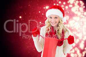 Composite image of happy festive blonde with shopping bag