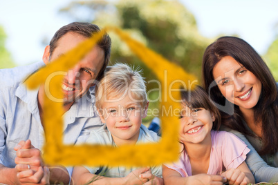 Composite image of family lying down in the park