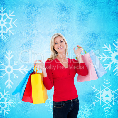 Composite image of happy blonde holding shopping bags