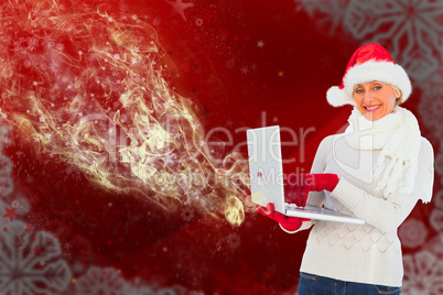 Composite image of festive woman holding laptop