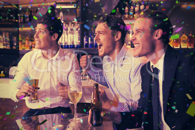 Composite image of handsome friends having a drink together