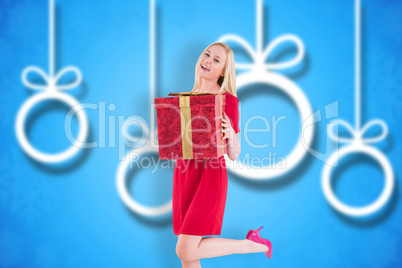 Composite image of pretty blonde in red dress holding gift