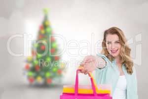 Composite image of smiling blonde woman offering shopping bags