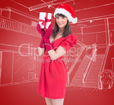 Composite image of brunette in santa hat holding a gift