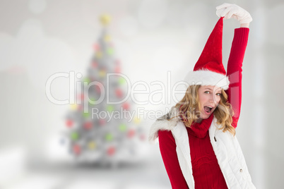 Composite image of cheering woman in santa hat