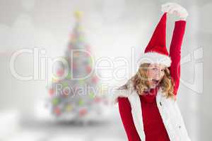 Composite image of cheering woman in santa hat