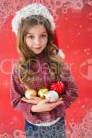 Composite image of festive little girl smiling at camera holding baubles