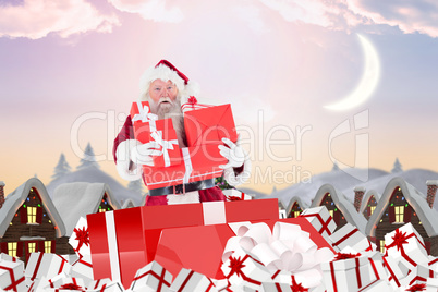 Composite image of santa standing in large gift