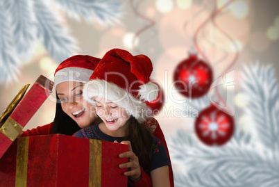 Composite image of mother and daughter opening gift