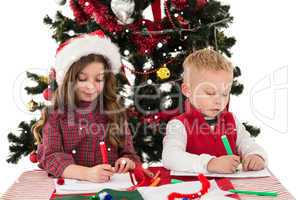 Composite image of festive little siblings drawing pictures
