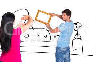 Composite image of young couple hanging a frame