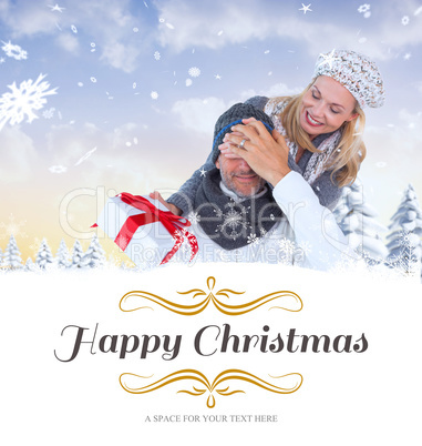 Composite image of happy winter couple with gift