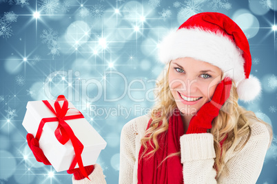 Composite image of happy festive blonde with gift