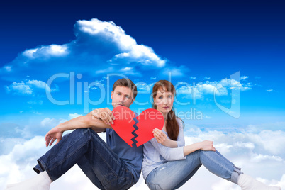Composite image of couple holding a broken heart