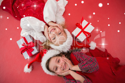 Composite image of festive little girls smiling at camera with g