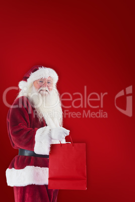 Composite image of santa carries red gift bag