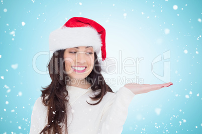 Composite image of festive brunette holding hand out