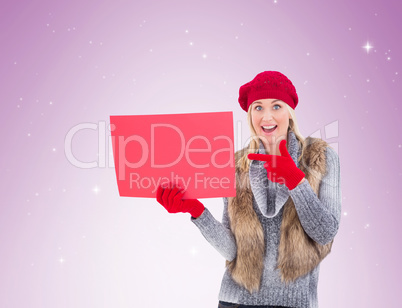 Blonde in winter clothes holding red sign