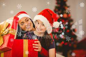 Composite image of festive mother and daughter opening a christm