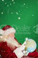 Composite image of father christmas pointing to globe