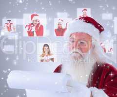 Composite image of santa claus reads a list