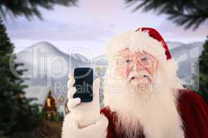 Composite image of santa claus shows a smartphone