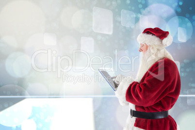 Composite image of santa uses a tablet pc