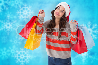 Composite image of cheerful brunette holding shopping bags